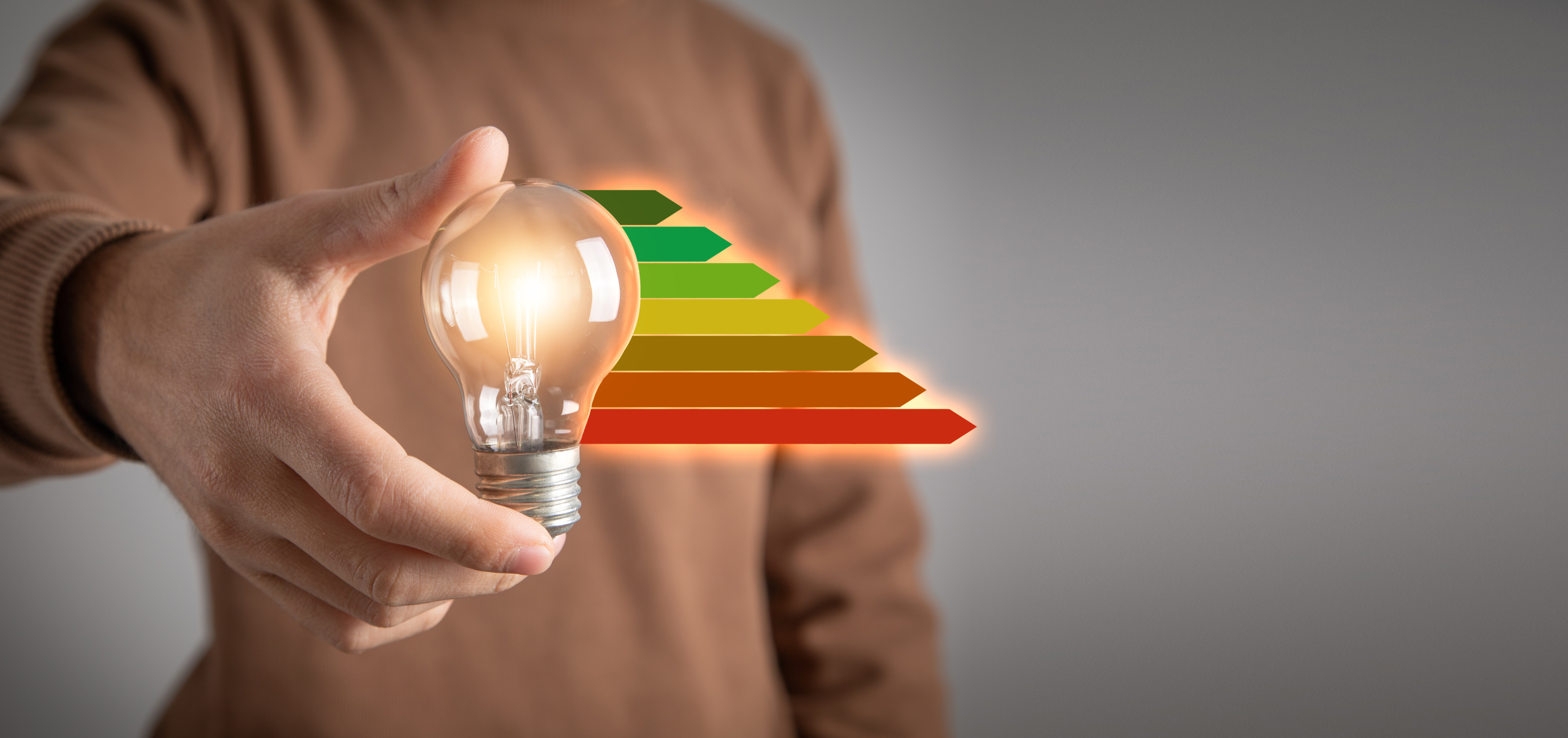Hand holding a lightbulb with energy rating